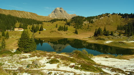 A-wide-angle-image-of-a-mountain-with-a-beautiful-house-by-the-lake-in-Korbersee-Austria