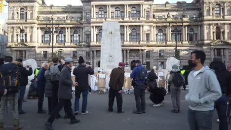 A-crowd-of-people-watching,-photographing,-and-filming-a-climate-change-protest-performance