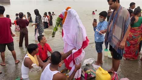 La-Gente-Está-Realizando-Rituales-Con-Kola-Bou-En-La-Orilla-Del-Río-Ganges-Durante-El-Festival-Durga-Puja-En-Kolkata