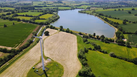 Flying-over-a-wind-turbine-in-farmers-field-by-Boddington-reservoir-and-beautiful-English-countryside-in-Northamptonshire