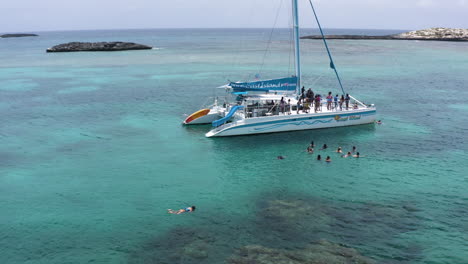 AERIAL---People-at-a-boat-party,-Cayo-Lobos,-Fajardo,-Puerto-Rico,-spinning-shot