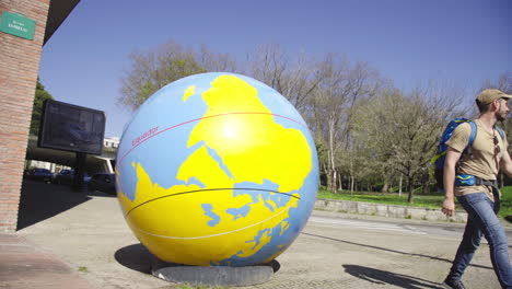 Skulptur-Des-Planeten-Erde-Im-Stadtzentrum-Der-Wichtigsten-Touristenattraktion-Mit-Kaukasischem-Jungen-Mann
