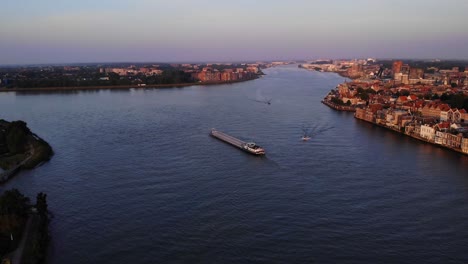 High-Aerial-View-Over-Oude-Maas-With-Ships-Passing-Below-During-Sunset-Light-In-Dordrecht