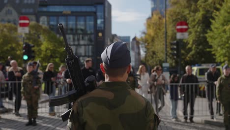 Parte-Posterior-Del-Soldado-Masculino-Con-Pistola-De-Pie-En-Karl-Johan,-Oslo-Durante-El-Desfile-Militar