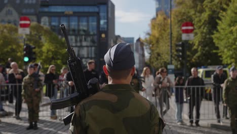 Back-of-male-soldier-with-gun-standing-on-Karl-Johan,-Oslo-during-military-parade