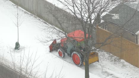 High-Angle-View-Of-A-Tractor-Plowing-Snow-On-The-Sidewalk-At-Winter