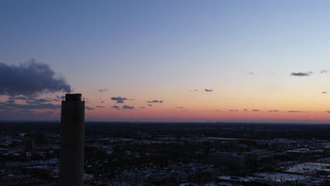 An-aerial-view-high-over-an-industrial-area-on-Long-Island,-NY-during-a-colorful-sunset