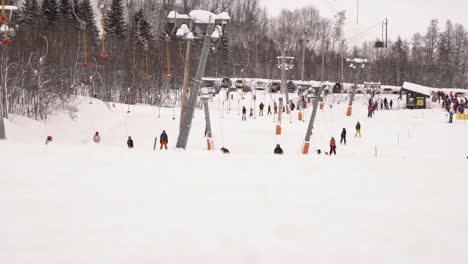 A-busy-day-with-children-and-families-riding-ski-lift-in-Myrkdalen-Norway---Static-clip-with-snow-foreground