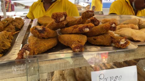 Crumbed-golden-fried-fish-fingers-in-sticks-served-on-brown-paper-on-a-rustic-wood-counter-with-tartare-sauce-in-a-close-up-view-with-one-broken-open-in-the-street-of-Kolkata-West-Bengal