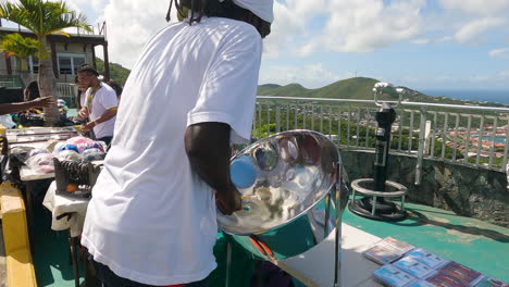 Slow-motion-tilt-up-shot-of-a-man-playing-on-a-steelpan-in-Saint-Thomas,-USVI