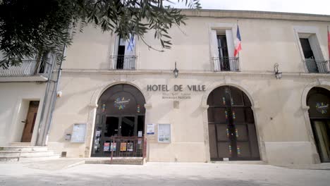 Main-entrance-of-Hotel-de-Ville-with-flags-of-the-country-and-municipality,-Dolly-out-reveal-shot