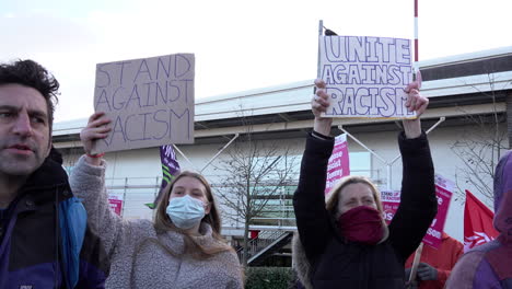 Zwei-Frauen-Halten-Während-Einer-Protestaktion-Gegen-Den-Rechtsextremen-Sprecher-Tommy-Robinson-Handgefertigte-Pappplakate-Mit-Der-Aufschrift-„Steht-Gegen-Rassismus“-Und-„Vereint-Gegen-Rassismus“-Hoch