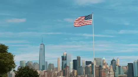 Una-Foto-Fija-De-La-Bandera-Americana-Ondeando-En-El-Viento-Con-El-Horizonte-De-Nueva-York-De-Fondo