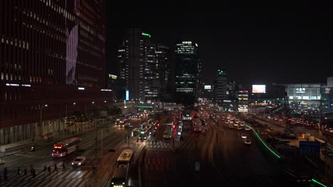 Nighttime-city-scene-of-a-busy-downtown-bus-terminal-in-Seoul,-South-Korea---slow-motion