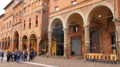 Shot-of-a-group-of-tourists-watching-the-old-historical-porticoes-in-Bologna,-Italy-at-daytime