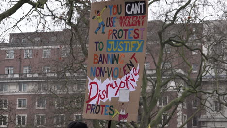 Menschen-Gehen-An-Einem-Hochgehaltenen-Bunten,-Handgefertigten-Pappschild-Vorbei,-Auf-Dem-Steht:-„Sie-Können-Gewalttätigen-Protest-Nicht-Nutzen,-Um-Das-Verbot-Gewaltfreier,-Störender-Proteste-Zu-Rechtfertigen.“