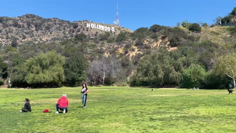 Aufnahme-Eines-Hollywood-Schildes-Mit-Spielenden-Menschen-Und-Hunden