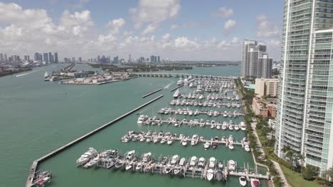 Low-flight-over-Miami-Beach-Marina,-downtown-Miami-seen-in-distance