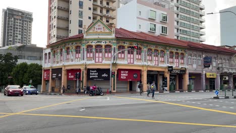 People-and-car-traffic-outside-Sim-Kwong-Ho-Shophouses,-Balestier