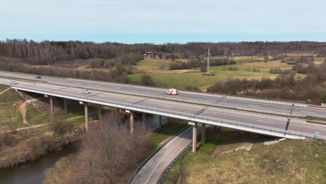 Aerila-shot,-the-highway-bridge-crosses-the-river,-cars-run-on-the-highway