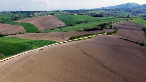 Luftaufnahme-Von-Hochspannungsleitungen-Und-Masten-über-Den-Feldern-In-Einer-Sonnigen-Ländlichen-Landschaft