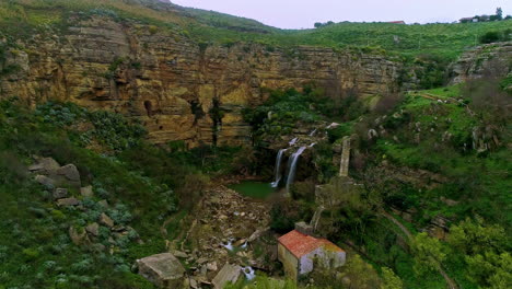 Aerial-view-of-Due-Rocche-waterfall-surrounded-by-scenic-mountains-in-Sicily,Italy