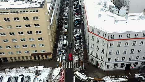 Aerial-view-over-cars-driving-on-quiet-streets,-wet-winter-day-in-Warsaw,-Poland