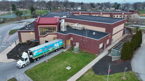 Milchlieferwagen-Entlädt-Milchprodukte-Am-Dock-Eines-Schulgebäudes-In-Den-USA
