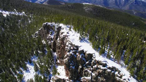 Aerial-Drone-Footage-Flying-Over-Mountain-Ridge-Covers-In-Snow-Surrounded-By-Pine-Trees-Near-Alpine-Rocky-Mountains-In-Mount-Evans-Colorado-USA