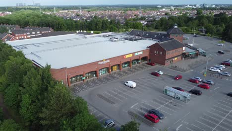 Aerial-view-flying-above-Morrisons-supermarket-car-park-in-rural-Warrington-countryside-village-panning-right-shot