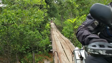 Motorcycles-carefully-cross-a-light-suspension-bridge-in-the-Brazilian-outback