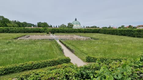 Landscape-of-Kvetna-zahrada-garden-in-Kromeriz,-Czech-Republic-with-a-pool-and-pavillion-in-the-background