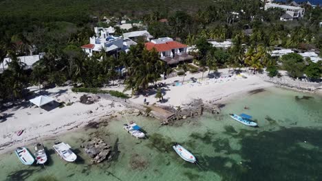 Aerial-shot-of-boat-sailing-in-the-corner-of-the-beach-at-Akumal,-Tulum,-Quintana-Roo,-Mexico