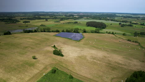 Leere-Polnische-Ländereien-Nach-Der-Ernte-Mit-Solarpanel-Kleiner-Bauernhof---Entfernte-Luftaufnahme