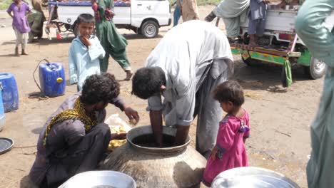 Mann-Sortiert-Lebensmittelrationen-Neben-Lastwagen-Während-Der-Fluthilfe-In-Belutschistan