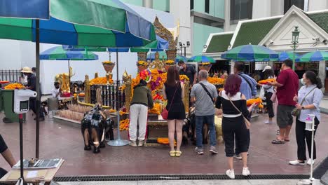 Visitors-praying-at-Four-Faced-Buddha-,-Erawan-Shrine,-Bangkok