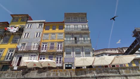 Ribeira-with-colourful-and-wonderfully-decorated-facades-and-Toy-Bird-Plane-Soaring-in-Sky