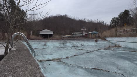 Slider-Footage-of-an-Abandoned,-Overgrown-Pool-at-the-Former-Fugates-Entertainment-Center-in-Eastern-Kentucky