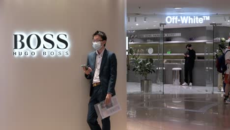 Un-Comprador-Se-Encuentra-Junto-A-La-Marca-De-Ropa-Alemana-Hugo-Boss-Store-En-Un-Centro-Comercial-En-Hong-Kong