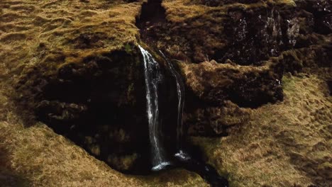 Luftaufnahme-Eines-Baches,-Der-Im-Winter-Einen-Wasserfall-In-Island-Hinunterfließt