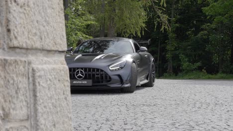 Black-Sports-Car-Driving-into-a-Driveway---Steady-Slow-motion-Handheld-Reveal-Shot