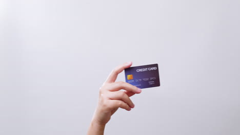 Woman's-hand-shows-a-credit-card-ready-for-shopping-online-in-white-studio-background-with-copy-space