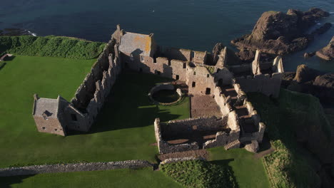aerial-view-downwards-over-the-ruins-of-the-scottish-dunnottar-castle-on-it's-rock-in-the-ocean