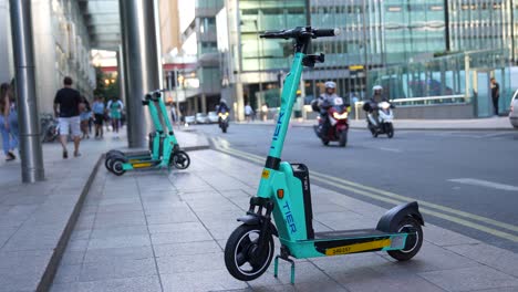 London-Canary-Wharf-Aug-2022-profile-establishing-shot-of-electric-scooter-waiting-by-the-side-of-the-road