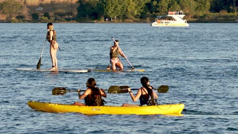 the-lake-paranoa-in-summer-with-people-on-the-water-with-paddle-boards-and-kayaks,-in-the-background-a-boat