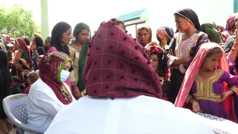 Gruppe-Von-Frauen,-Die-Im-Fluthilfelager-In-Sindh,-Pakistan,-Darauf-Warten,-Von-Hilfsärzten-Untersucht-Zu-Werden