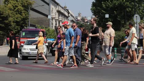 A-group-of-people-crossing-road-during-busy-traffic-in-Tbilisi,-Georgia