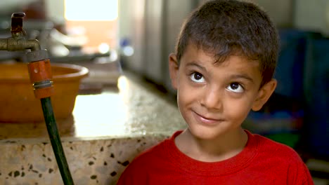 Ein-Kleiner-Junge-In-Gaza-Blickt-Mit-Großen,-Unschuldigen-Augen-In-Die-Kamera-Und-Steht-In-Einer-Küche