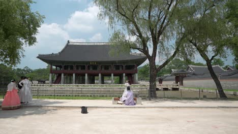 Turistas-Niñas-Vestidas-Con-Vestidos-Tradicionales-Hanbok-Junto-Al-Lago-Cerca-Del-Pabellón-Gyeonghoeru