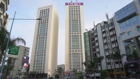 Slow-tilt-up-shot-of-the-Casablanca-Twin-Center-towers-from-Zerktouni-avenue,-low-angle-view